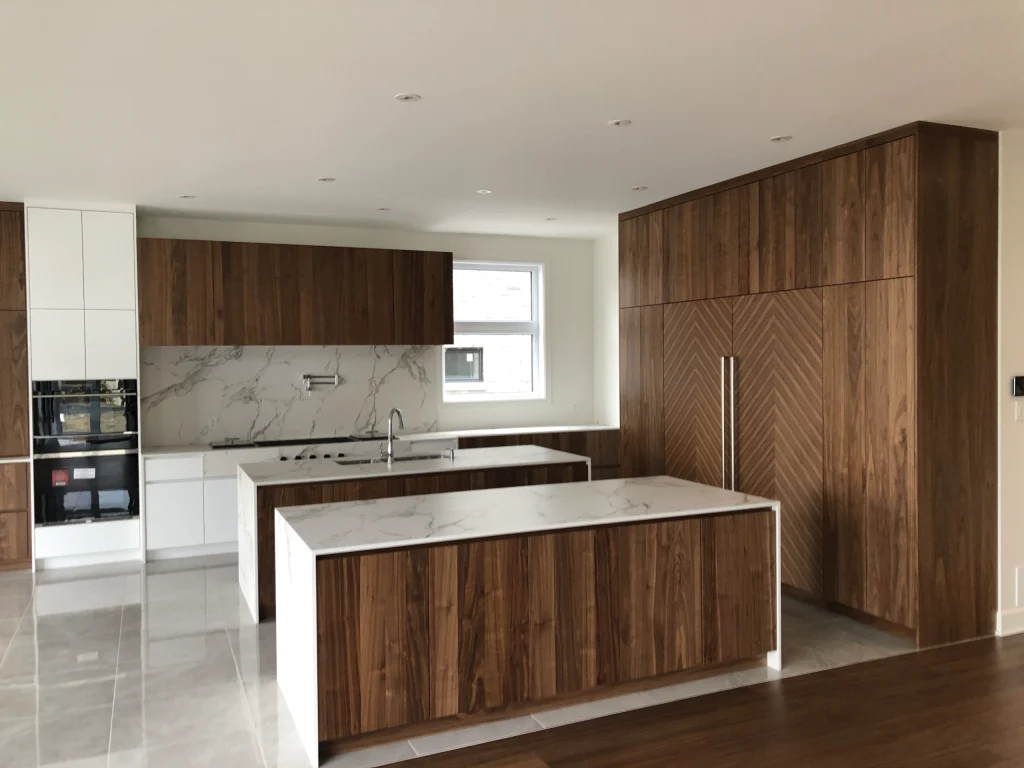 Custom refrigerator installation with built-in Thermador and Bosch units featuring chevron panels in Ville Saint-Laurent.