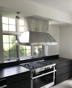 Large island hood installation in front of window for heavy cooking