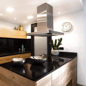 Bertazzoni island hood installation in modern high-contrast kitchen
